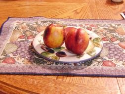 plate with two peaches on table