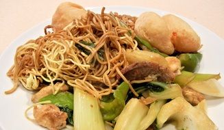 chinese noodles with other ingredients on a white plate