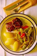 cutlets with potatoes and colorful beans in the bowl