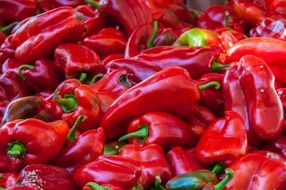 a big pile of red paprika in a market