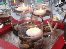 floating candles in glasses with water