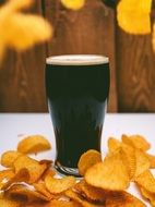 dark beer in glass and chips