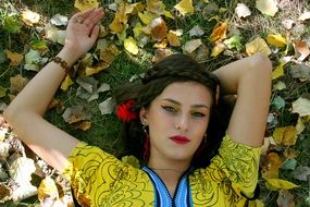 Girl with make-up in the autumn style on a background of yellow leaves