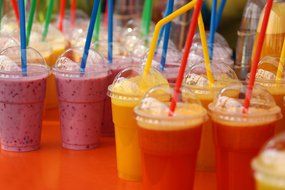 multicolored smoothies with straws