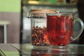 mango fruits tea in cup and in jar on table