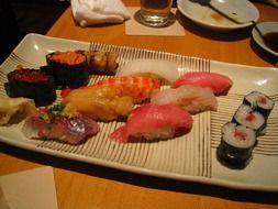raw sushi and rolls on dish
