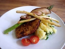 meat with asparagus and vegetables on a plate