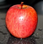 red apple in water drops