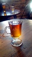 mulled wine in a transparent cup on a wooden table