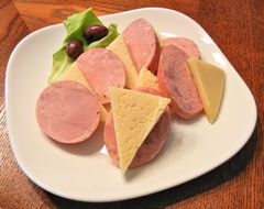 sliced ​​sausage and jarlsberg cheese on a white plate
