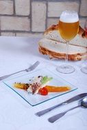 glass of beer with a snack on a background of sliced ââbread on the table