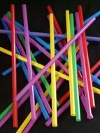 colorful drinking straws against a black background
