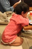 little baby sitting near the table