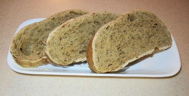 Three slices of bread with oregano on a white plate