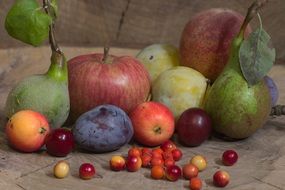 still life of ripe fruits and berries close up on the stump