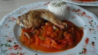 chicken leg, vegetables and rice at plate