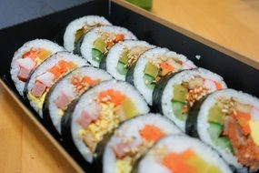 rice rolls with vegetables on black dish