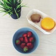 kiwi and strawberries in bowls on table