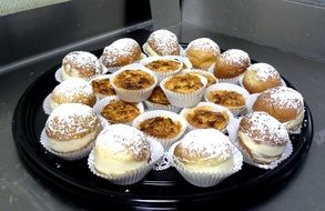 delicious cupcakes with powdered sugar on a tray