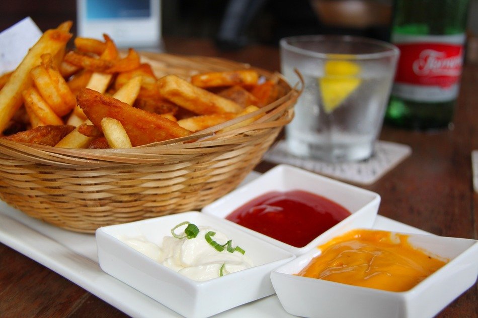 french fries in wicker basket with sauces