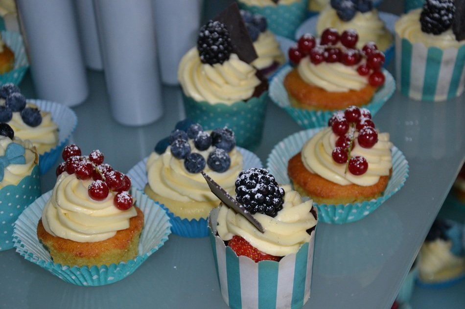 tasty cupcakes topped with whipped cream and fresh berries