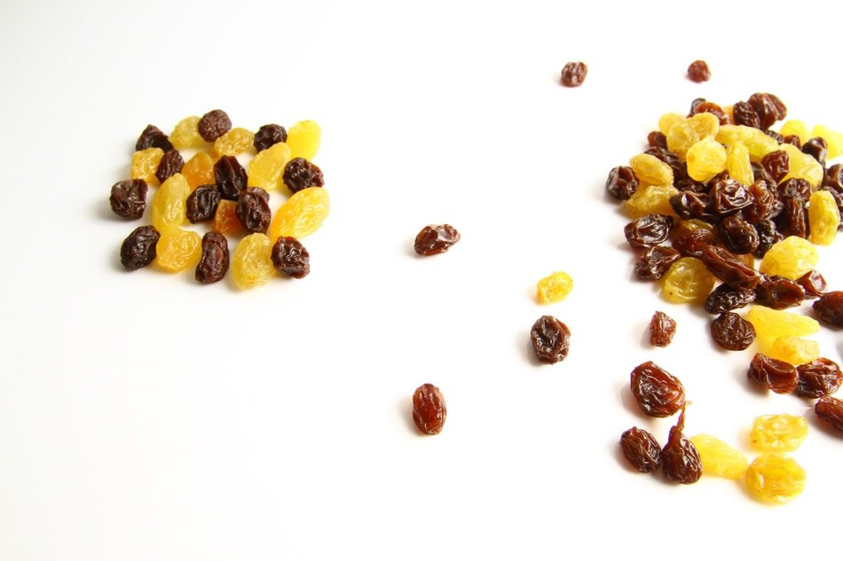 Yellow and brown raisins on a white table
