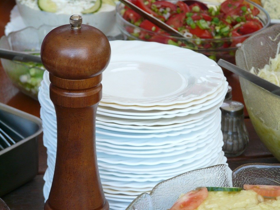 pepper mill and many white plates