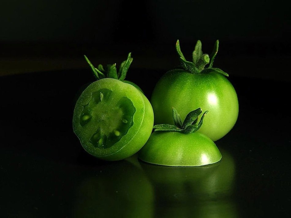 green tomato on a dark background