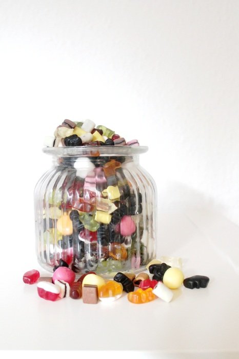 variety of colorful candies in a glass jar