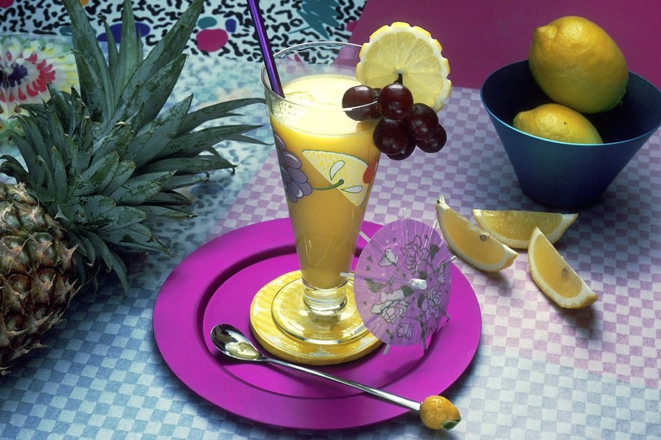 Beautiful fruit beverage in the glass and fruits on the table