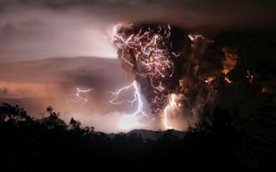 flashes and black clouds from an erupting volcano