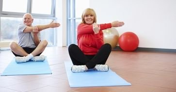 senior woman and man doing yoga exercises
