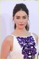 Emilia Clarke in a white dress with purple flowers