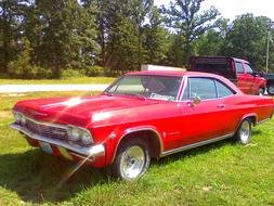 red 65 Chevrolet Impala on the lawn