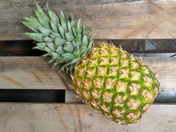 pineapple fruit on wooden plank