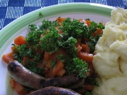 mashed potatoes, carrots and sausage on a plate