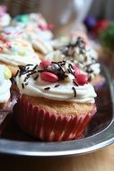 colorful sweet muffins garnished with whipped cream