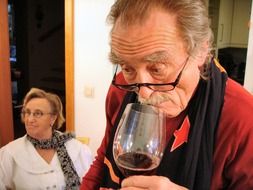 elderly man with a glass of red wine