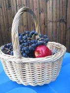 Red apples and blue grapes in the basket