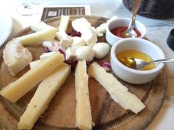 Parmezan and mozzarella cheeses on the wooden plate