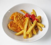 french fries and chicken nuggets in white bowl