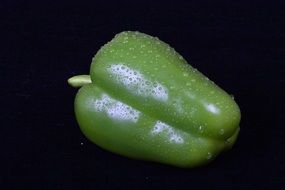 green sweet peppers on a black background