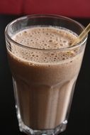 chocolate milkshake is in a glass with a tube