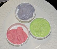 three small plates of yogurt with different tastes