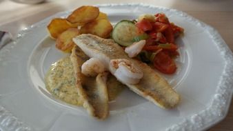 zander with vegetables on a white plate
