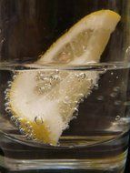 a slice of lemon with bubbles in the water