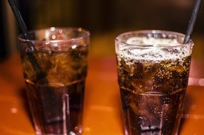 two glasses with fizzy brown drink