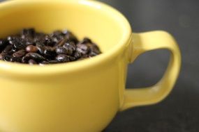 Coffee beans in the yellow coffee cup