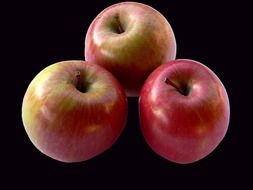 three red apples on a black background