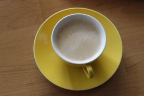 cup of coffee on a yellow saucer